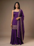 Model wearing a violet georgette sharara set with sequin embroidery and matching bordered dupatta